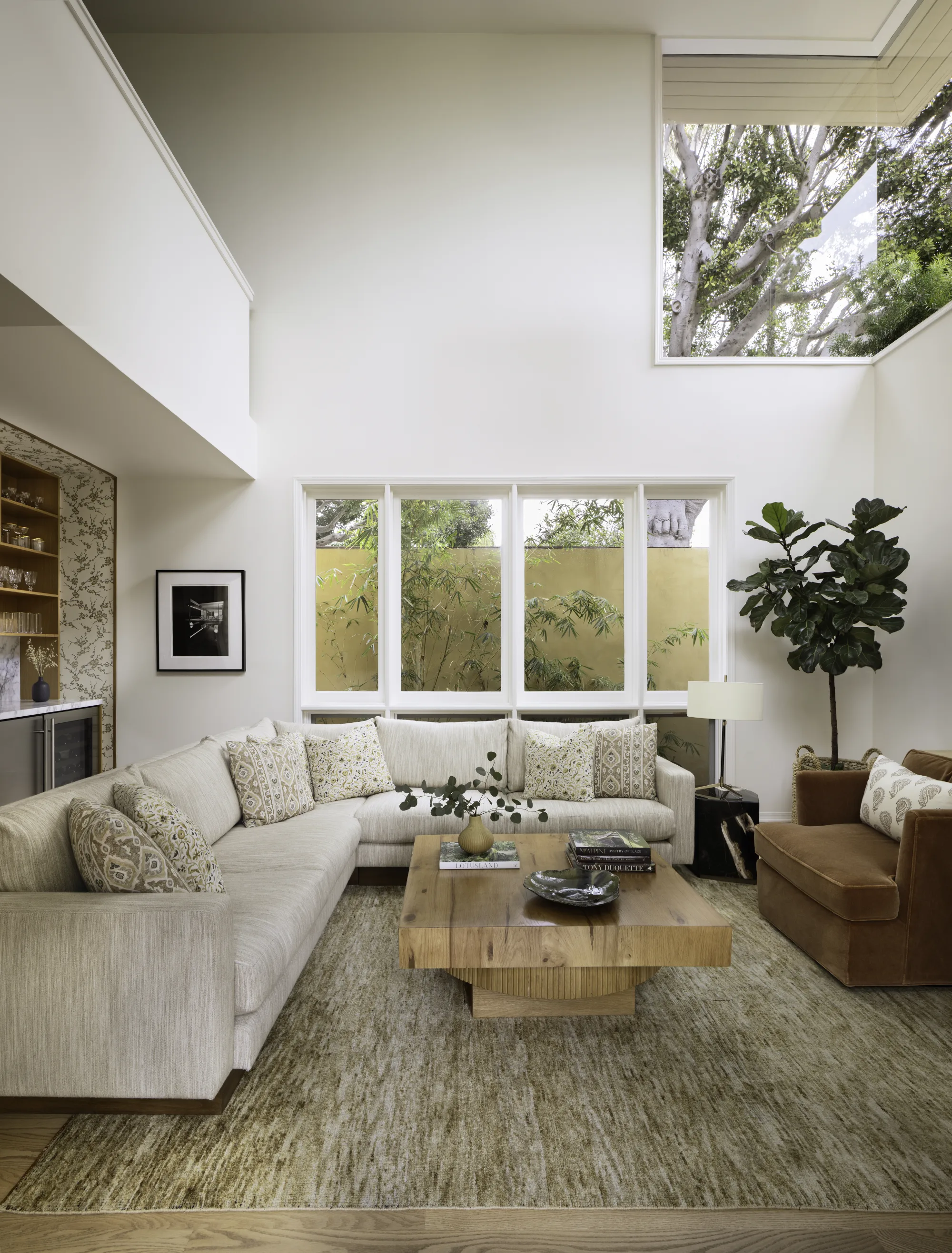 Double-height family room with a white sectional, a wood coffee table and clerestory windows