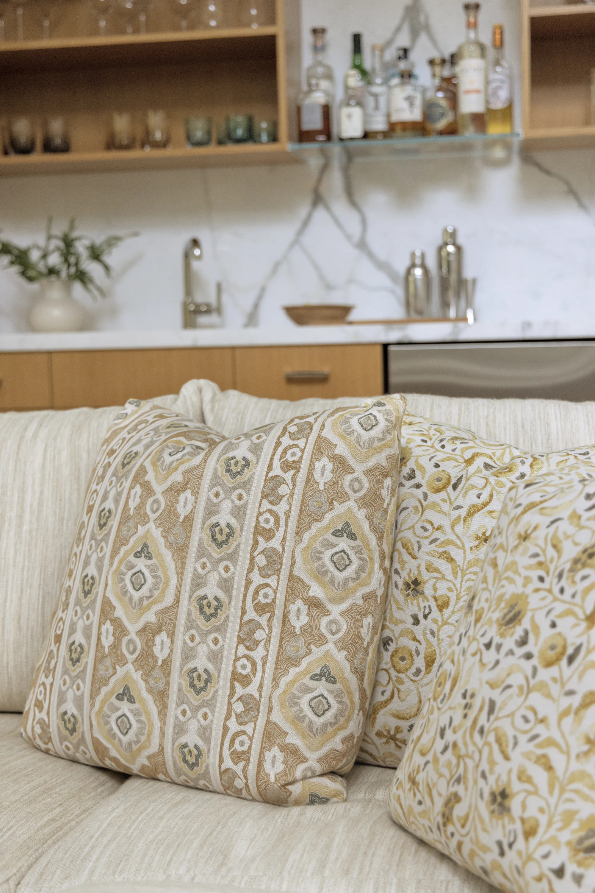 Block-print pillows on the sofa in front of the wet bar