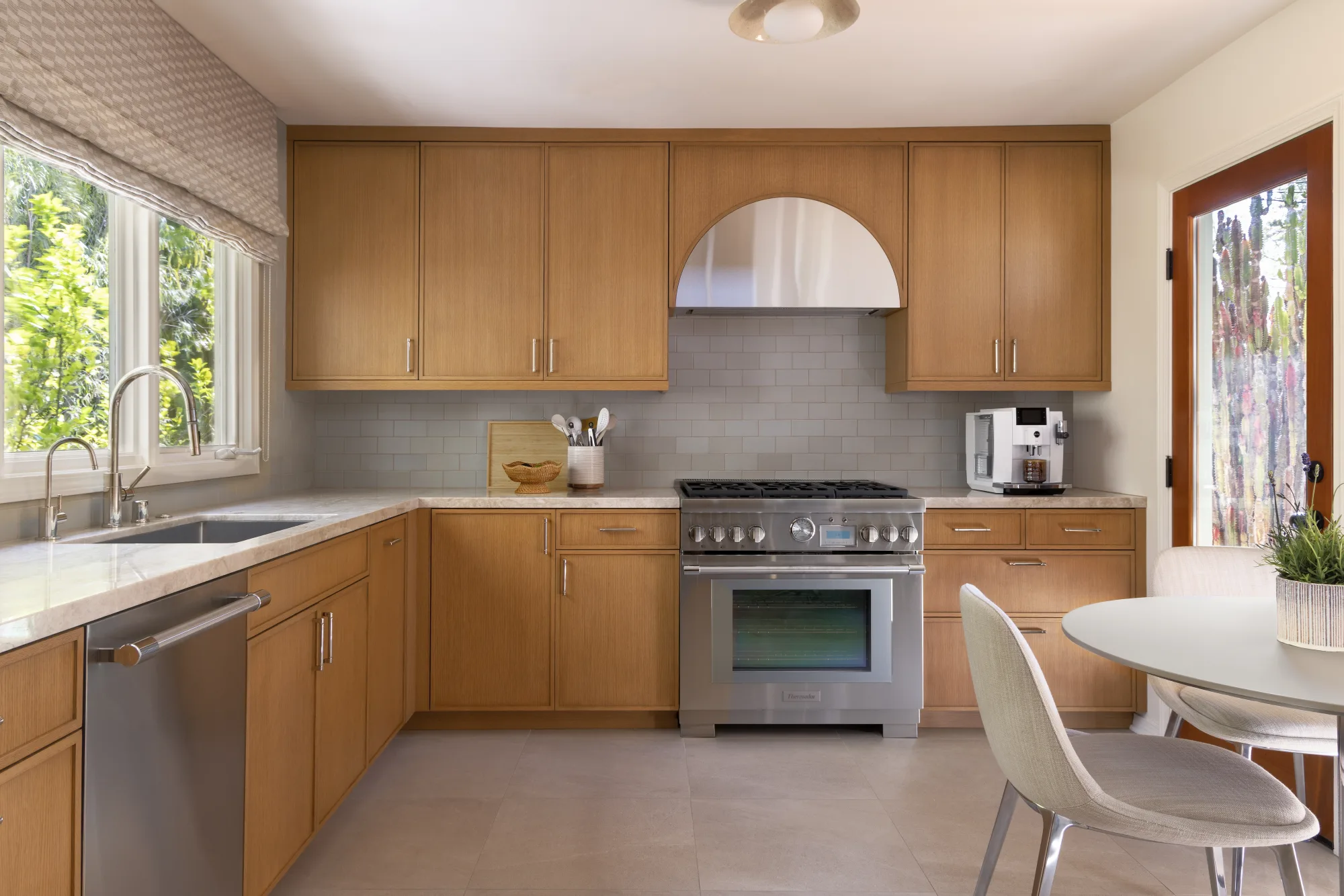 Kitchen with oak cabinetry, an arched range hood and a professional range