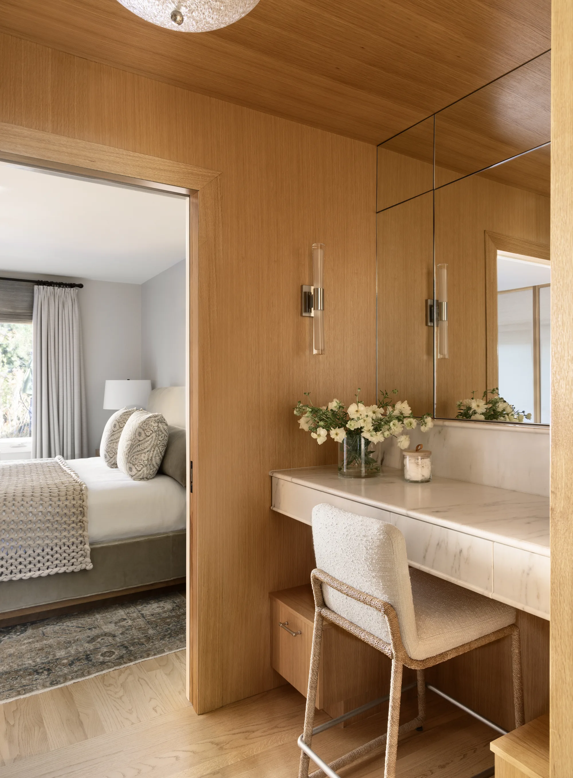 Oak-paneled vanity with a stool, opening onto the bedroom