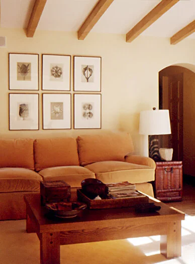 A family room with a comfortable upholstered sofa. In front is a low wooden coffee table.