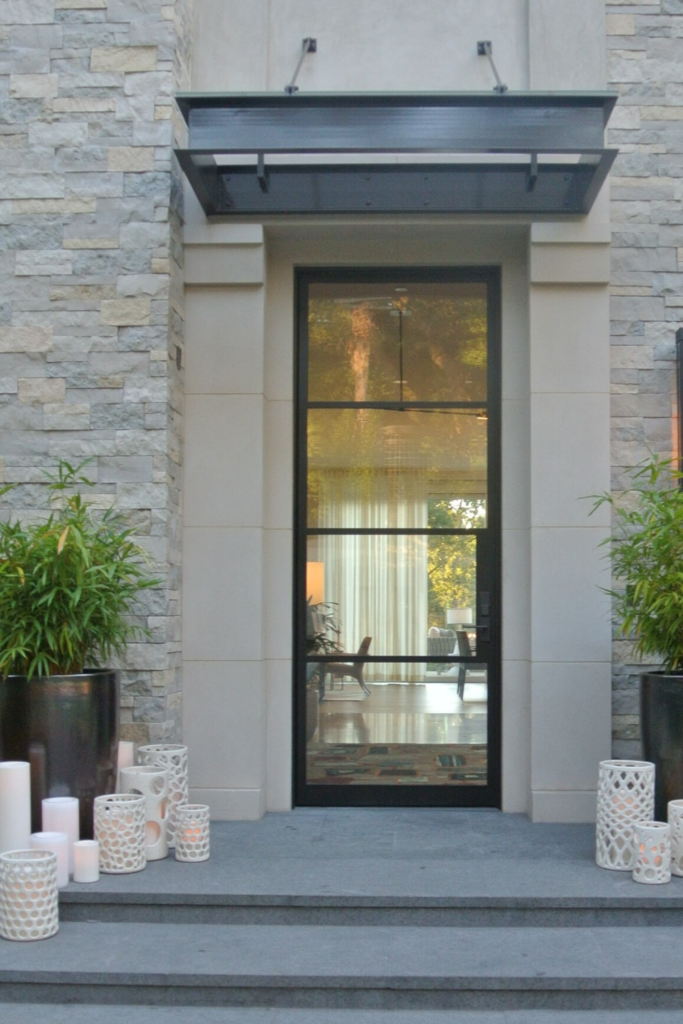 This home in Northern Californias, Silicon Valley, has a simple metal and glass front door. It creates an inviting feel as it allows you to peek inside which creates a sense of openness and warmth, almost as if you are invited right in.